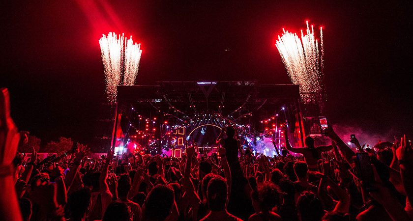 group of people in front of a stage with fireworks display